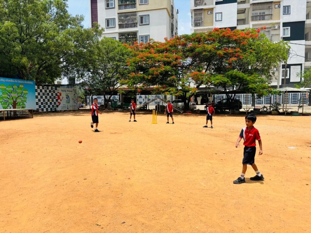 Children playing cricket on playground with trees at best preschool in Miyapur.